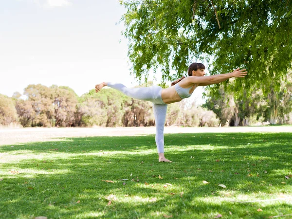 Jonge vrouw het beoefenen van yoga in het park — Stockfoto