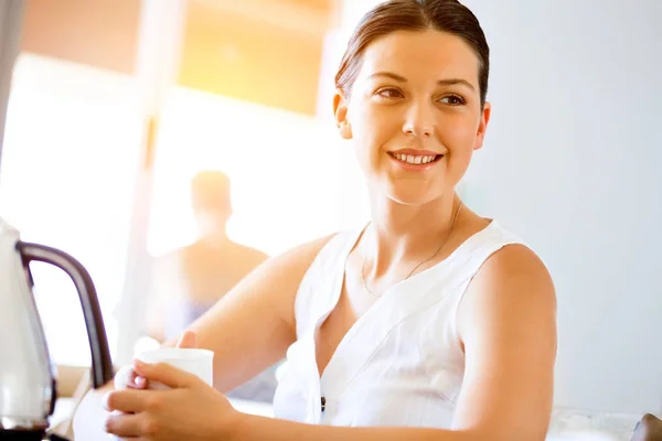 Mujer joven feliz con taza de té o café en casa —  Fotos de Stock