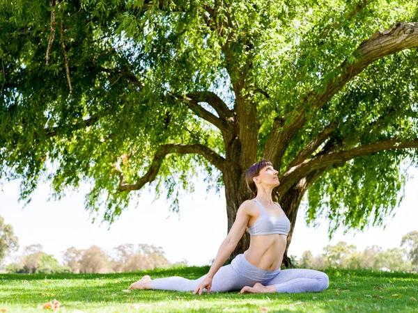 在公园练习瑜伽的年轻女子 — 图库照片