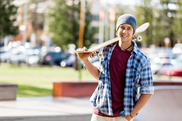 Мальчик-подросток со скейтбордом стоит на улице — стоковое фото