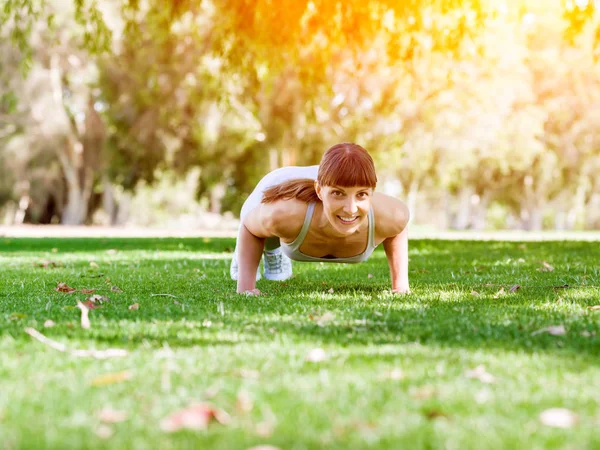 Jeune femme faisant de l'exercice dans le parc Images De Stock Libres De Droits