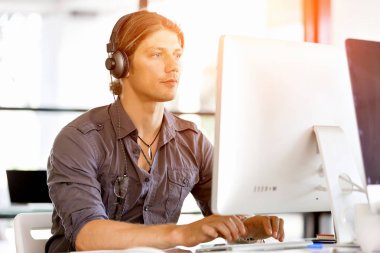 Kulaklıklar ile ofiste genç adam