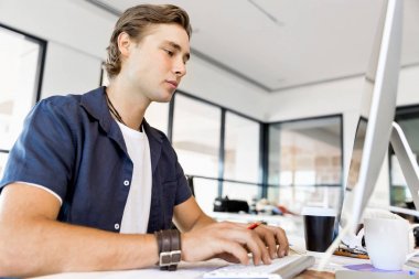 Bilgisayarda çalışan yakışıklı işadamı