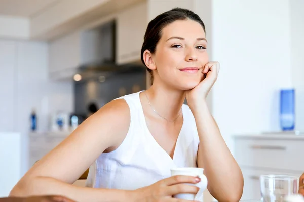 Mujer joven feliz con taza de té o café en casa — Foto de Stock