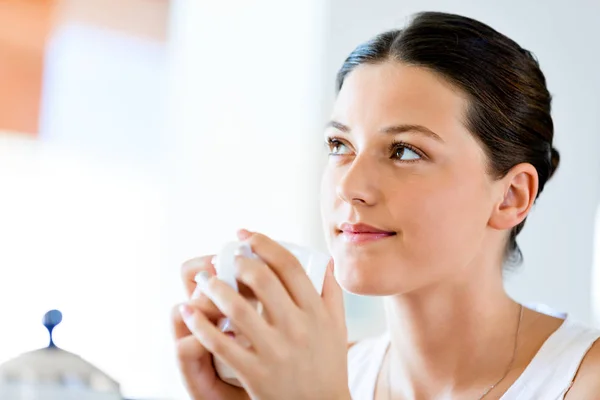 Mujer joven feliz con taza de té o café en casa — Foto de Stock