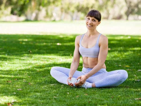 Genç kadın parkta yoga yapıyor. — Stok fotoğraf