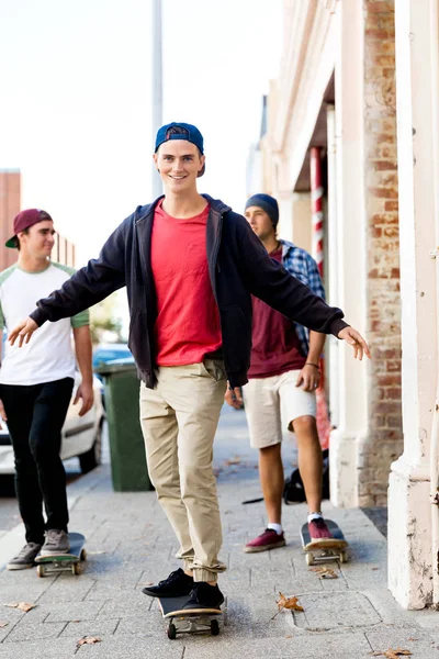 Jeugdvrienden lopen in de straat met skateboards — Stockfoto