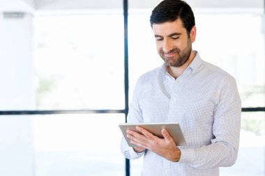 Genç yakışıklı işadamı onun touchpad ayakta kullanma office