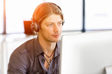 Kulaklıklar ile ofiste genç adam