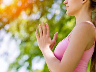 Parkta yoga yapan genç kadın.