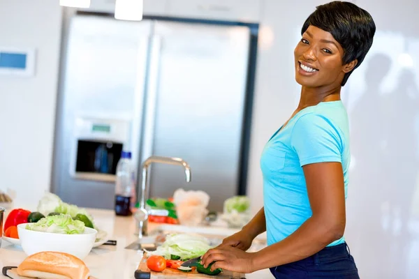Красива жінка стоїть на кухні і посміхається — стокове фото