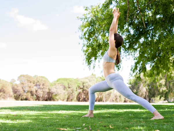 Mujer joven practicando yoga en el parque — Foto de Stock