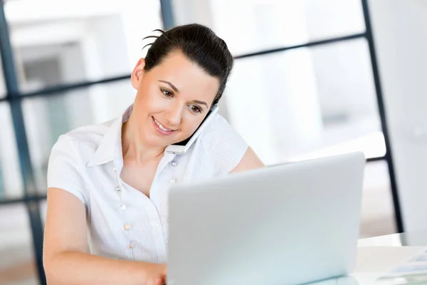 Geschäftsfrau mit Handy im Büro — Stockfoto