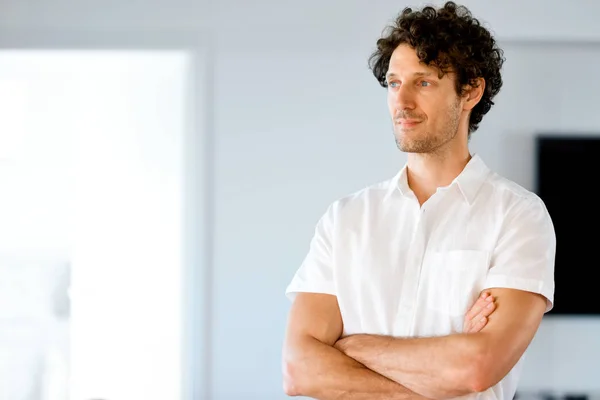 Portrait d'un jeune homme intelligent debout dans la cuisine — Photo