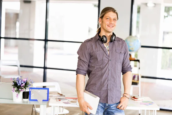 Νεαρός επιχειρηματίας Καυκάσιος στέκεται στο γραφείο — Φωτογραφία Αρχείου