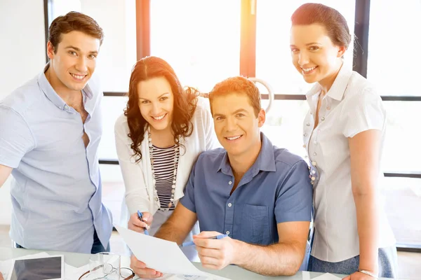 Groep van gelukkige jonge zakenmensen in een vergadering — Stockfoto