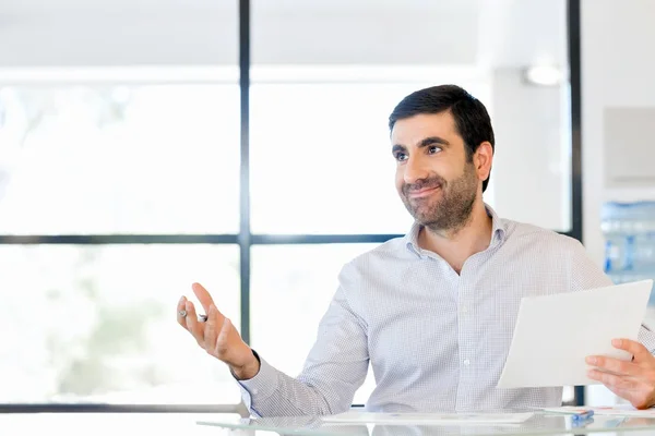 Guapo joven sosteniendo papel en la oficina — Foto de Stock