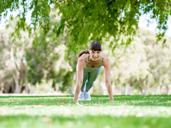 Jeune femme faisant de l'exercice dans le parc — Photo