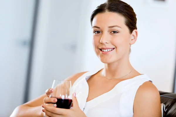 Hermosa mujer joven sosteniendo copa con vino tinto — Foto de Stock