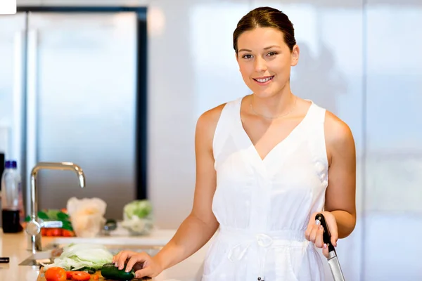 Mulher bonita de pé na cozinha e sorrindo — Fotografia de Stock