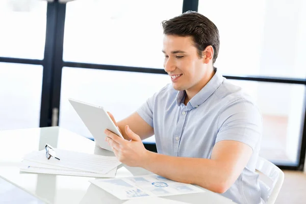 Junger gutaussehender Geschäftsmann sitzt mit seinem Touchpad im Büro — Stockfoto