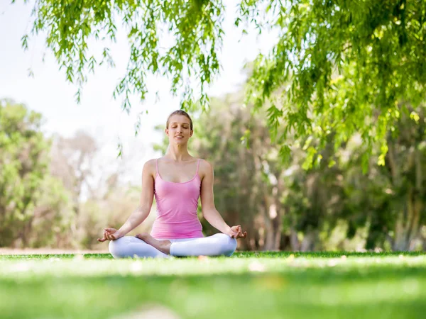 Junge Frau macht Yoga im Park — Stockfoto