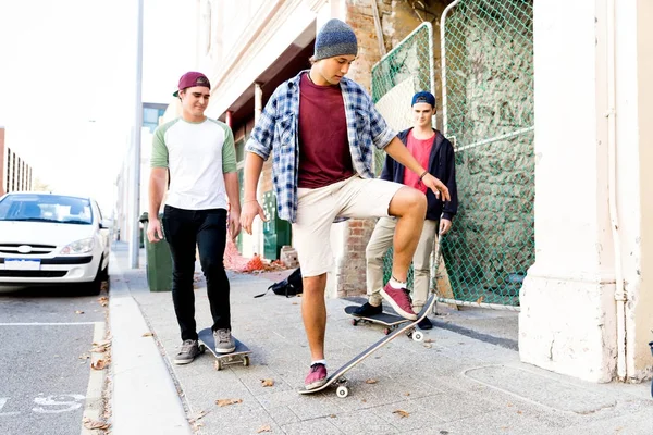 Amis adolescents marchant dans la rue avec des planches à roulettes — Photo