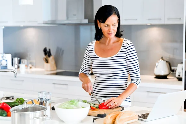 Schöne Frau steht in der Küche und kocht — Stockfoto