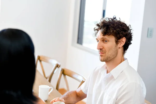 Portrait of man sitting and talking to woman indoors — Stock Photo, Image