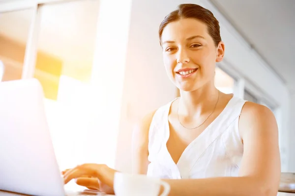 Jovem mulher bonita trabalhando em seu laptop — Fotografia de Stock