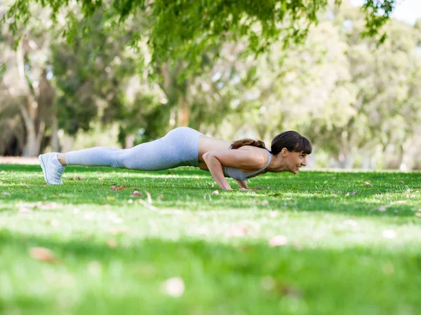 Jovem mulher se exercitando no parque — Fotografia de Stock