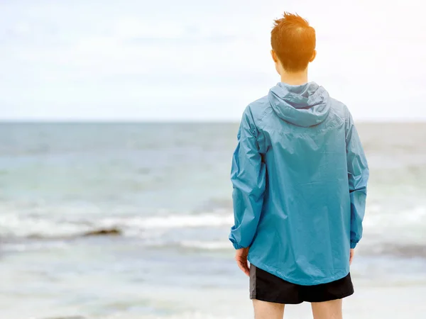 Молодой человек стоит на пляже — стоковое фото