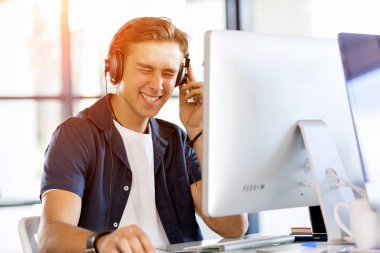 Kulaklıklar ile ofiste genç adam