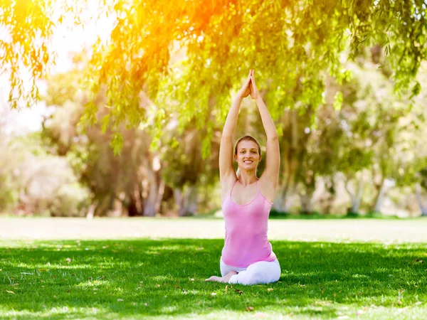 Giovane donna che fa yoga nel parco — Foto Stock