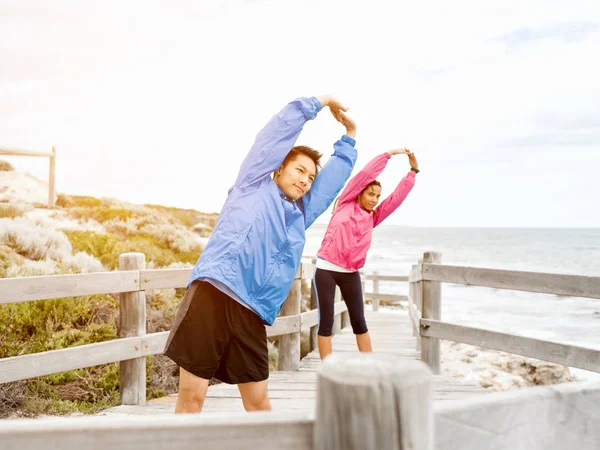 Egzersizleri yapıyor deniz kenarında genç Çift — Stok fotoğraf