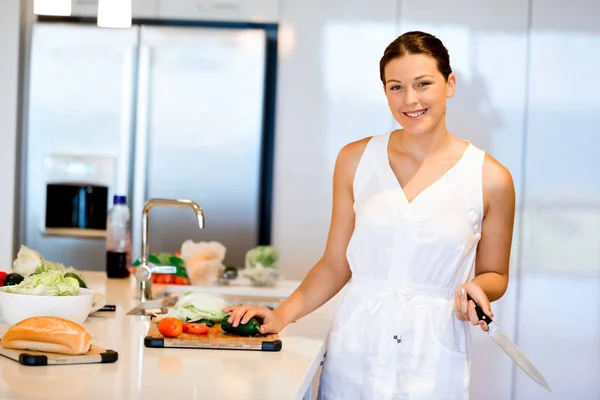 Mulher bonita de pé na cozinha e sorrindo — Fotografia de Stock