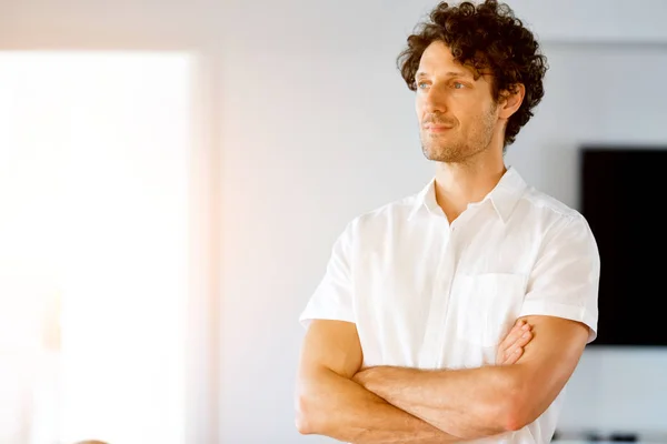 Portrait of a smart young man standing in kitchen — Stock Photo, Image