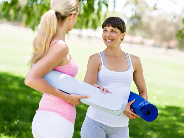 İki genç kadın bir spor salonu ile parkta sohbet mat — Stok fotoğraf