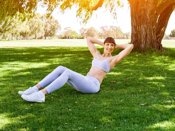 Jovem mulher se exercitando no parque — Fotografia de Stock