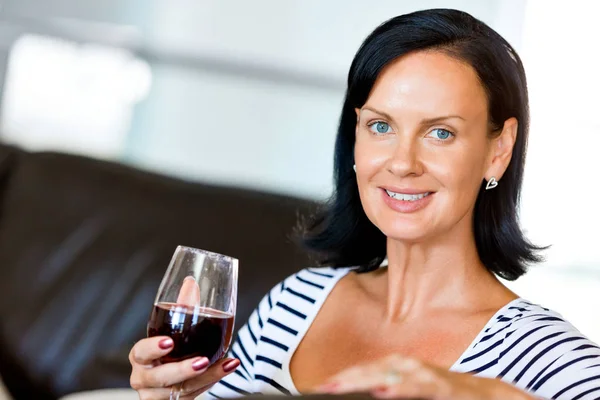 Beautiful young woman holding glass with red wine — Stock Photo, Image