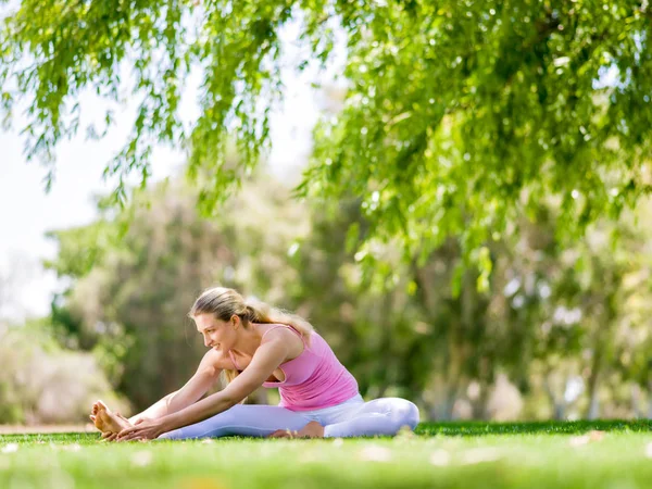 Giovane donna che fa yoga nel parco — Foto Stock