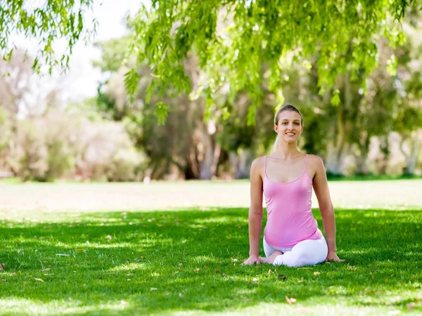Parkta yoga yapan genç kadın. — Stok fotoğraf