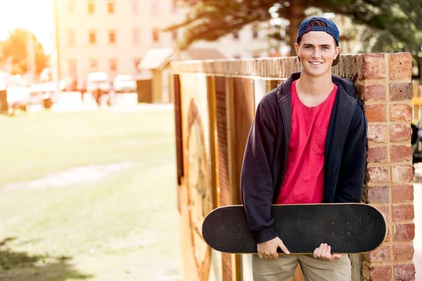 Ragazzo adolescente con skateboard in piedi all'aperto — Foto Stock