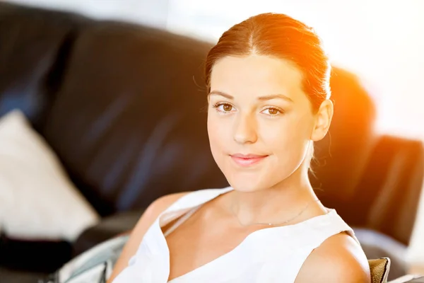 Glückliche Frau beim Lesen einer Zeitschrift auf einem Sofa sitzend — Stockfoto