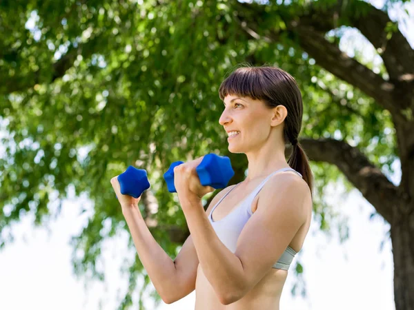 Portrét veselé ženy v fitness oblečení cvičit s činka — Stock fotografie