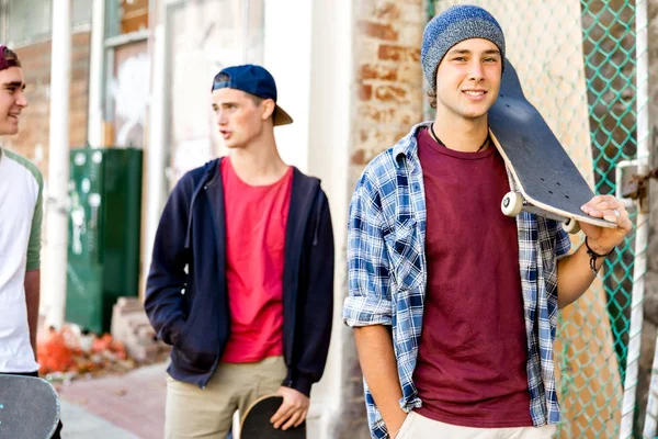 Amigos adolescentes caminando por la calle con patinetas — Foto de Stock