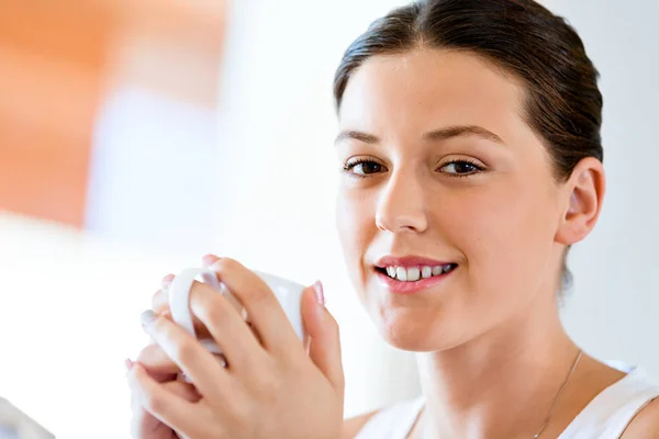 차 또는 집에서 커피 한잔과 함께 행복 한 젊은 여자 — 스톡 사진