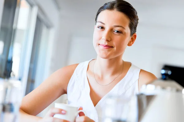 Mujer joven feliz con taza de té o café en casa —  Fotos de Stock