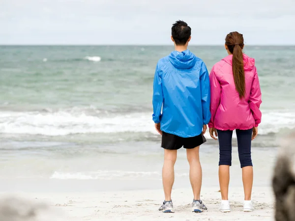 Jeune couple debout à la plage — Photo