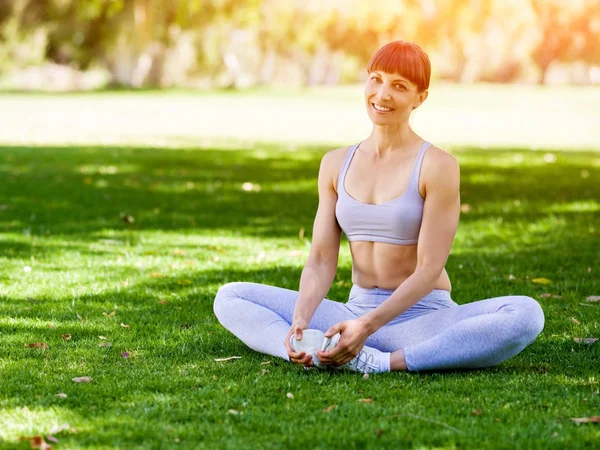 Jonge vrouw het beoefenen van yoga in het park — Stockfoto